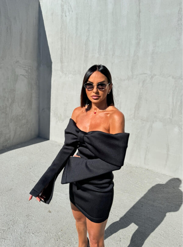 Mini crna elegantna haljina dugih rasečenih rukava, otkrivenih ramena i dekolteom u vidu mašne
