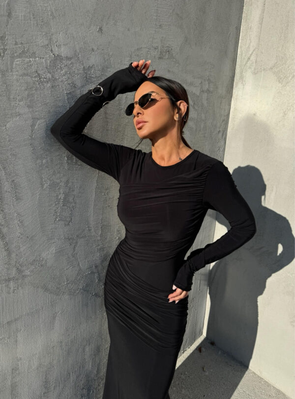 Duga uska elegantna crna haljina dugih rukava sa naborima preko grudi i bokova.