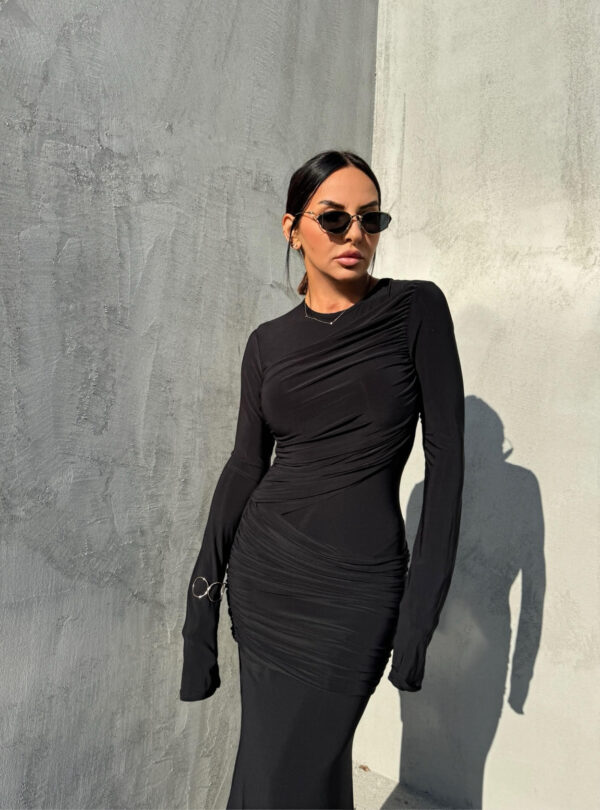 Duga uska elegantna crna haljina dugih rukava sa naborima preko grudi i bokova.