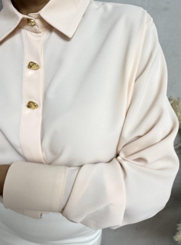 Elegantna košulja sa zlatnim dugmadima nežne pastelne boje kajsije