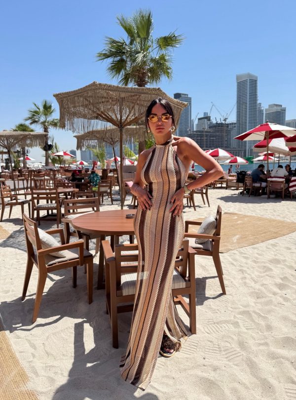 Duga pletena haljina za plažu na pruge zemljanih tonova sa halter dekolteom, vezivanjem na vratu i otvorenim leđima