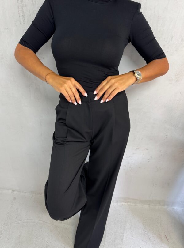 Crne trendi zvonaste pantalone plićeg struka sa kosim džepovima