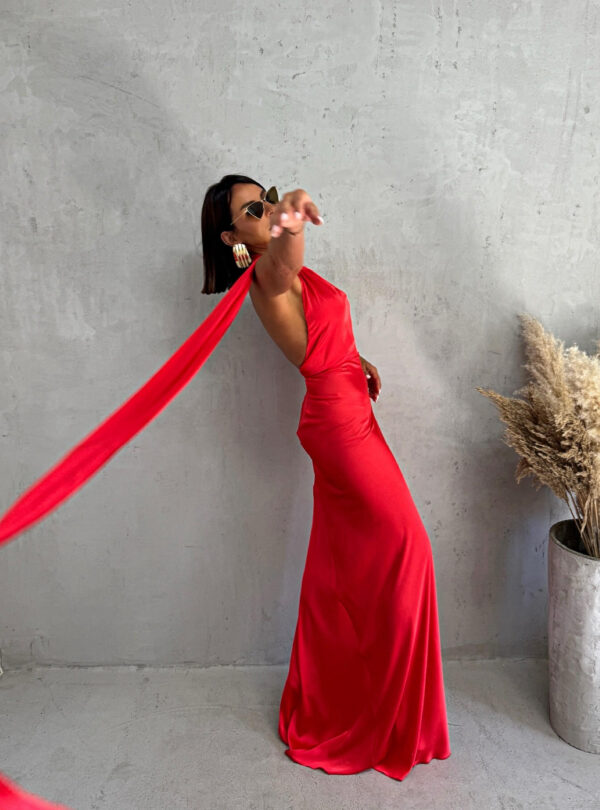 Duga crvena satenska haljina sa vezivanjem oko vrata i dekorativnim plaštom otvorenih leđa