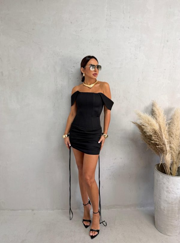 Mini crna haljina sa izraženim korsetom, debljim bretelama koje padaju sa ramena, naborana sa dekorativnim trakama