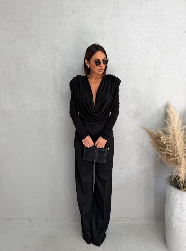 Crna bluza dugih rukava naglašenih ramena i bogatih nabora na grudima