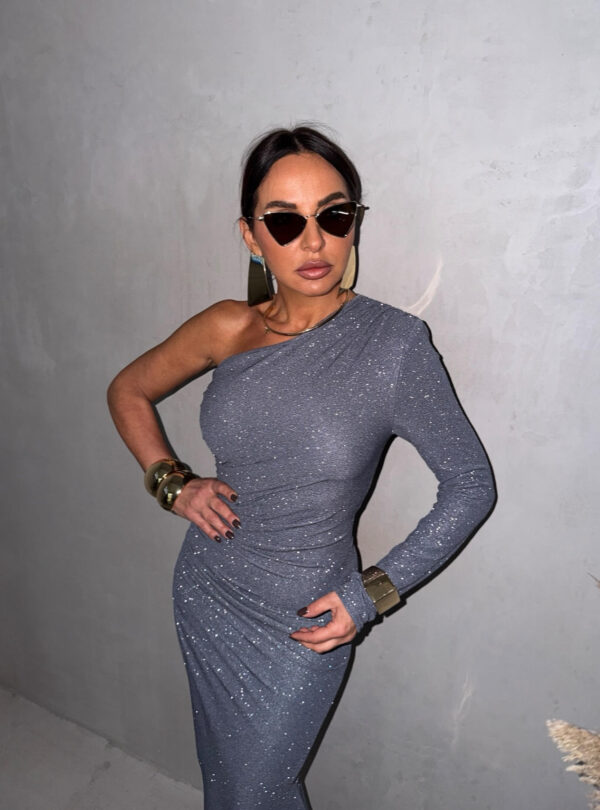 Duga srebrna svetlucava asimetrična haljina sa jednim dugim rukavom i dubokim šlicem sa suprotne strane