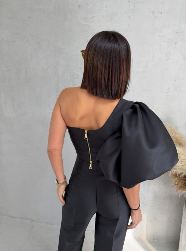 Crni komplet od čvrstog punijeg satena koji se sastoji od zvonastih pantalona visokog struka i kropovane asimetrične bluze sa predimenzioniranim rukavom