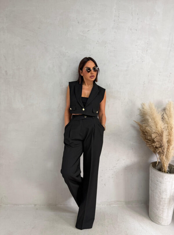 Crni komplet prsluka i zvonastih pantalona visokog struka sa kosim džepovima